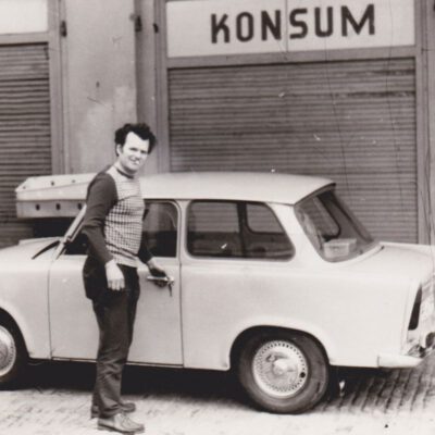 S/W Fotoaufnahme eines Mannes vor einem Trabbi und geschlossenem Konsumgeschäfts: Im Kutschstall der Villa Mendelsohn Bartholdy befand sich ein Lebensmittelgeschäft »Konsum« (1970er Jahre) - Foto: Privatbesitz